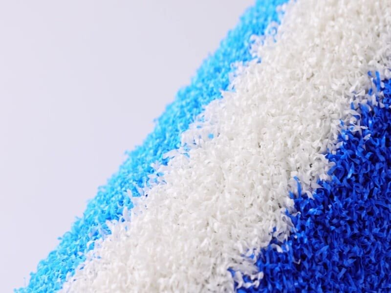 Cross-section of artificial turf showing primary and secondary backing layers